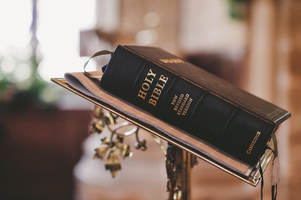 service-02 Holy Bible open on a stand inside a church, symbolizing faith and spirituality.