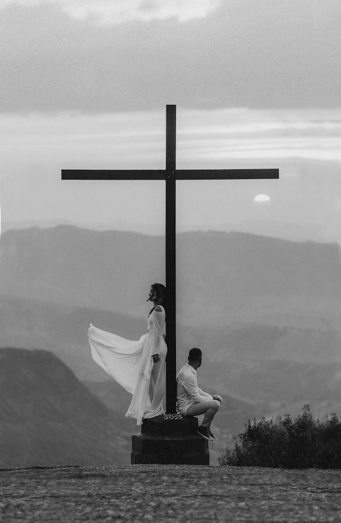 service-01 A serene moment of spiritual reflection by a cross at sunset with a dramatic sky in the background.