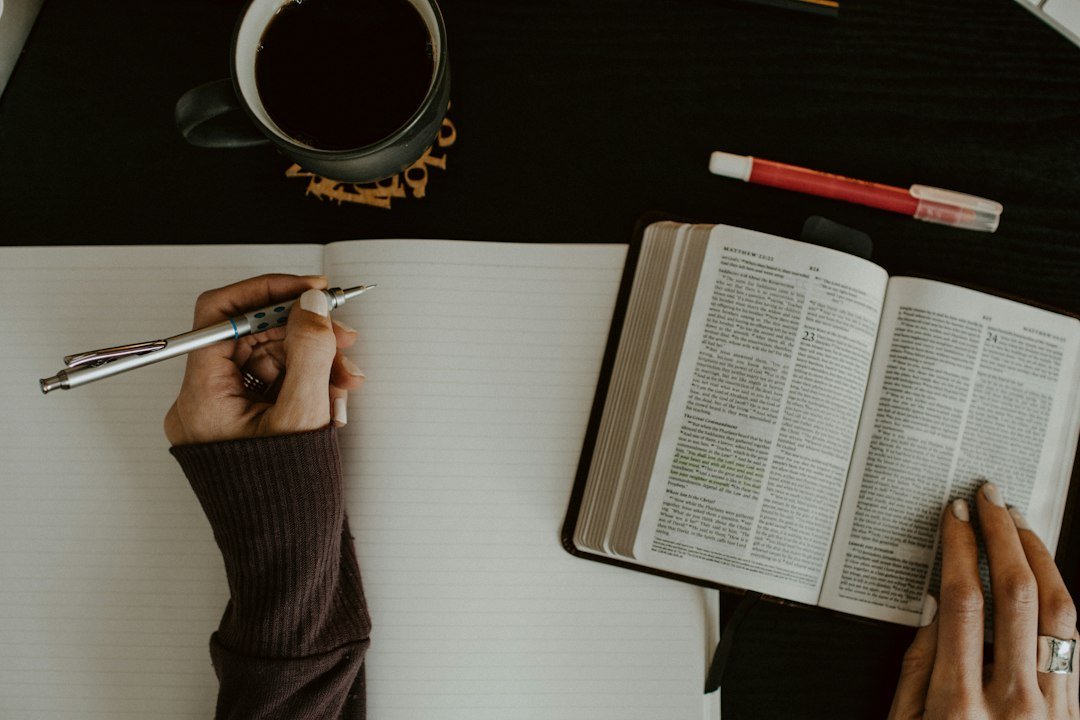 Woman studying an open Bible with a notebook, representing women of the Bible, faith and purpose